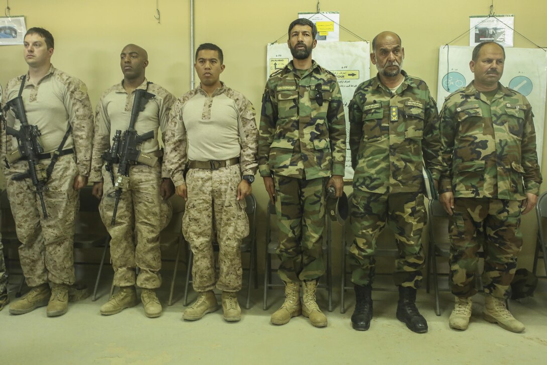 U.S. Sailors with Task Force Southwest and soldiers with the Afghan National Army 215th Corps stand as the Afghan National Anthem plays during a Helmand Regional Military Training Center graduation ceremony at Camp Shorabak, Afghanistan, April 26, 2017. More than 60 ANA soldiers recently completed a six-week medical training course instructed by the U.S. Army unit Task Force Forge. (U.S. Marine Corps photo by Sgt. Lucas Hopkins)