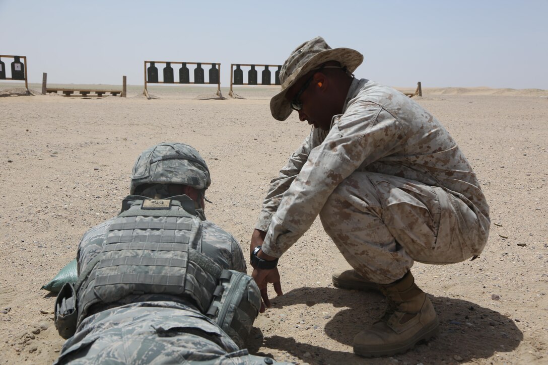 U.S. Marine Corps Gunnery Sgt. Leslie Yearwood, a radio chief with Marine Wing Support Squadron 372, Special Purpose Marine Air-Ground Task Force-Crisis Response-Central Command, coaches U.S. Airforce Senior Airman Johnathan Raye, an engineer with the 407th Expeditionary Civil Engineer Squadron, during a battle sight zero range while forward deployed in the Middle East, April 23, 2017. The training was conducted to ensure SPMAGTF Marines are prepared to react and respond to a variety of scenarios that may occur across the USCENTCOM area of operations. SPMAGTF-CR-CC is a well-trained crisis response unit that has the ability to project combat power over vast distances using organic aviation, logistical, and ground combat assets. (U.S. Marine Corps photo by Lance Cpl. Joshua S. McAlpine)