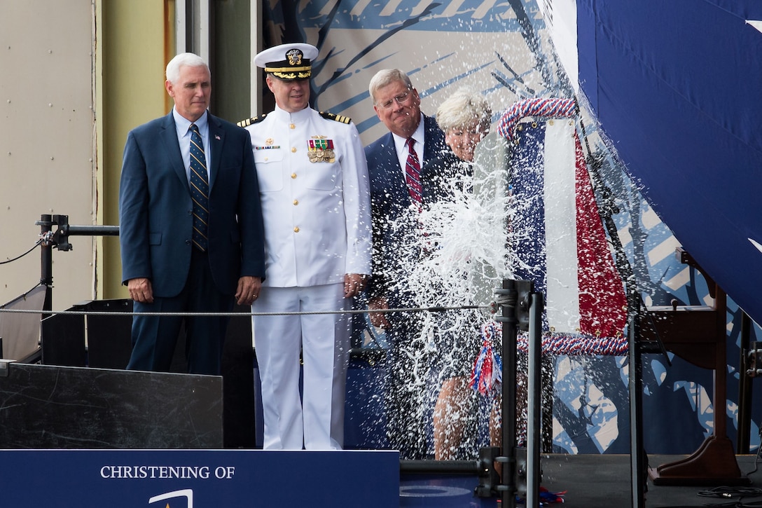 Vice President Mike Pence, left, looks on as Diane Donald christens the Virginia-class submarine, the future USS Indiana, at Newport News, Va., April 29, 2017. Also on hand are Navy Cdr. Jesse Zimbauer, the submarine's commanding officer, and Newport News Shipbuilding President Matt Mulherin. Navy photo by Ashley Major courtesy Huntington Ingalls Industries