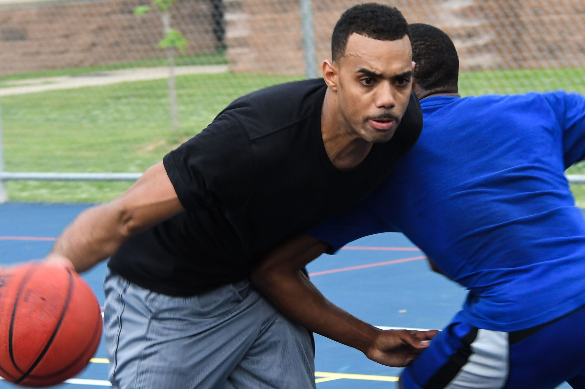 A member of the 307th Bomb Wing works his way past a defender during Family Fun Day at Barksdale Air Force Base, La., April 29, 2017. A large crowd of Airmen and their families participated in a basketball tournament held in conjunction with Family Fun Day.   Still more chose to participate in bowling, golf, horseshoes, archery and skeet shooting during the annual event.   (U.S. Air Force photo by Tech. Sgt. Ted Daigle/Released)