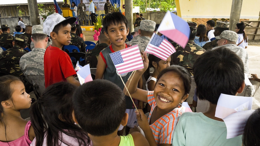 Filipino children wave U.S. and Philippine flags during a groundbreaking ceremony for Balikatan 2017 in Ormoc City, Leyte, April 25, 2017. Leaders from the Armed Forces of the Philippines, U.S. military, and Ormoc City gathered to commemorate the beginning of engineering projects for new classrooms at Margen Elementary School in Ormoc City. Balikatan is an annual U.S.-Philippine military bilateral exercise focused on a variety of missions, including humanitarian assistance and disaster relief and counterterrorism.