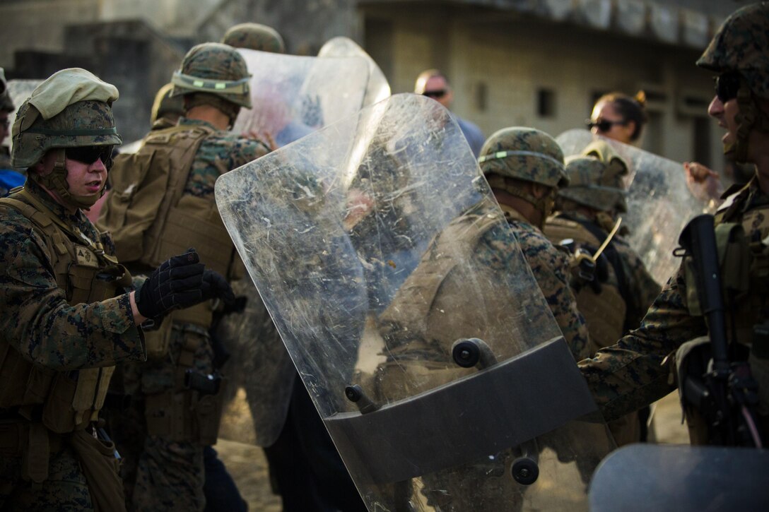 Marines defend against role players at Central Training Area, Camp Hansen, Okinawa, Japan, April 19, 2017. 3d Law Enforcement battalion conducted a Marine Corps Combat Readiness Evaluation to test each company’s ability to execute tasks ranging from policing operations to police patrolling, route regulations, key leader engagements in towns and local population centers, security of key infrastructure, identity operations and law enforcement operations in an expeditionary environment to ensure they are prepared to support the operational requirements of III Marine Expeditionary Force. The Marines are with Charlie Company, 3d LE Bn, III MEF Headquarters Group. (U.S. Marine Corps photo by Lance Cpl. Joshua Pinkney)