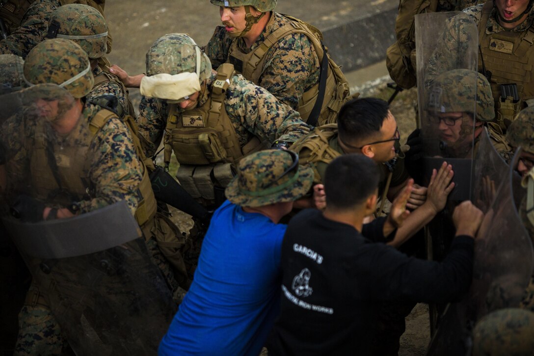 Marines repel role players during non-lethal weapons training at Central Training Area, Camp Hansen, Okinawa, Japan, April 18, 2017. 3d Law Enforcement battalion conducted a Marine Corps Combat Readiness Evaluation to test each company’s ability to execute tasks ranging from policing operations to police patrolling, route regulations, key leader engagements in towns and local population centers, security of key infrastructure, identity operations and law enforcement operations in an expeditionary environment to ensure they are prepared to support the operational requirements of III Marine Expeditionary Force. The Marines are with Charlie Company, 3d LE Bn, III MEF Headquarters Group. (U.S. Marine Corps photo by Lance Cpl. Joshua Pinkney)
