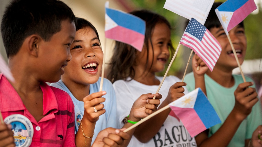 Filipino children wave U.S. and Philippine flags during a groundbreaking ceremony for Balikatan 2017 in Ormoc City, Leyte, April 25, 2017. Leaders from the Armed Forces of the Philippines, U.S. military, and Ormoc City gathered to commemorate the beginning of engineering projects for new classrooms at Margen Elementary School in Ormoc City. Balikatan is an annual U.S.-Philippine military bilateral exercise focused on a variety of missions, including humanitarian assistance and disaster relief and counterterrorism. 