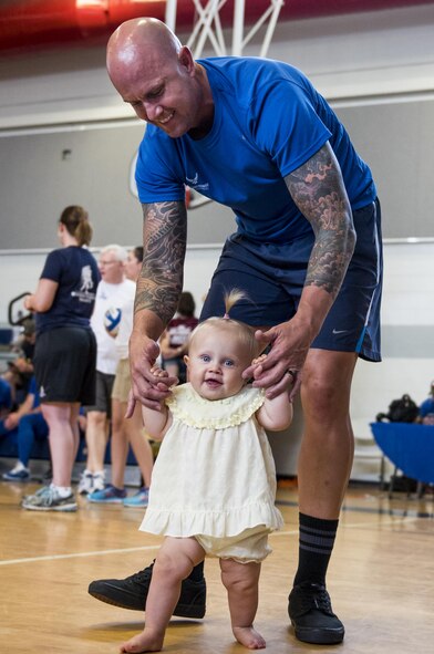 Adam Faine, a Warrior Games athlete, takes his 10-month-old  daughter, Hadley, for a walk during some down time at the Air Force team’s training camp at Eglin Air Force Base, Fla., April 28. The base-hosted, week-long Warrior Games training camp is the last team practice session before the yearly competition in June. (U.S. Air Force photo/Samuel King Jr.)