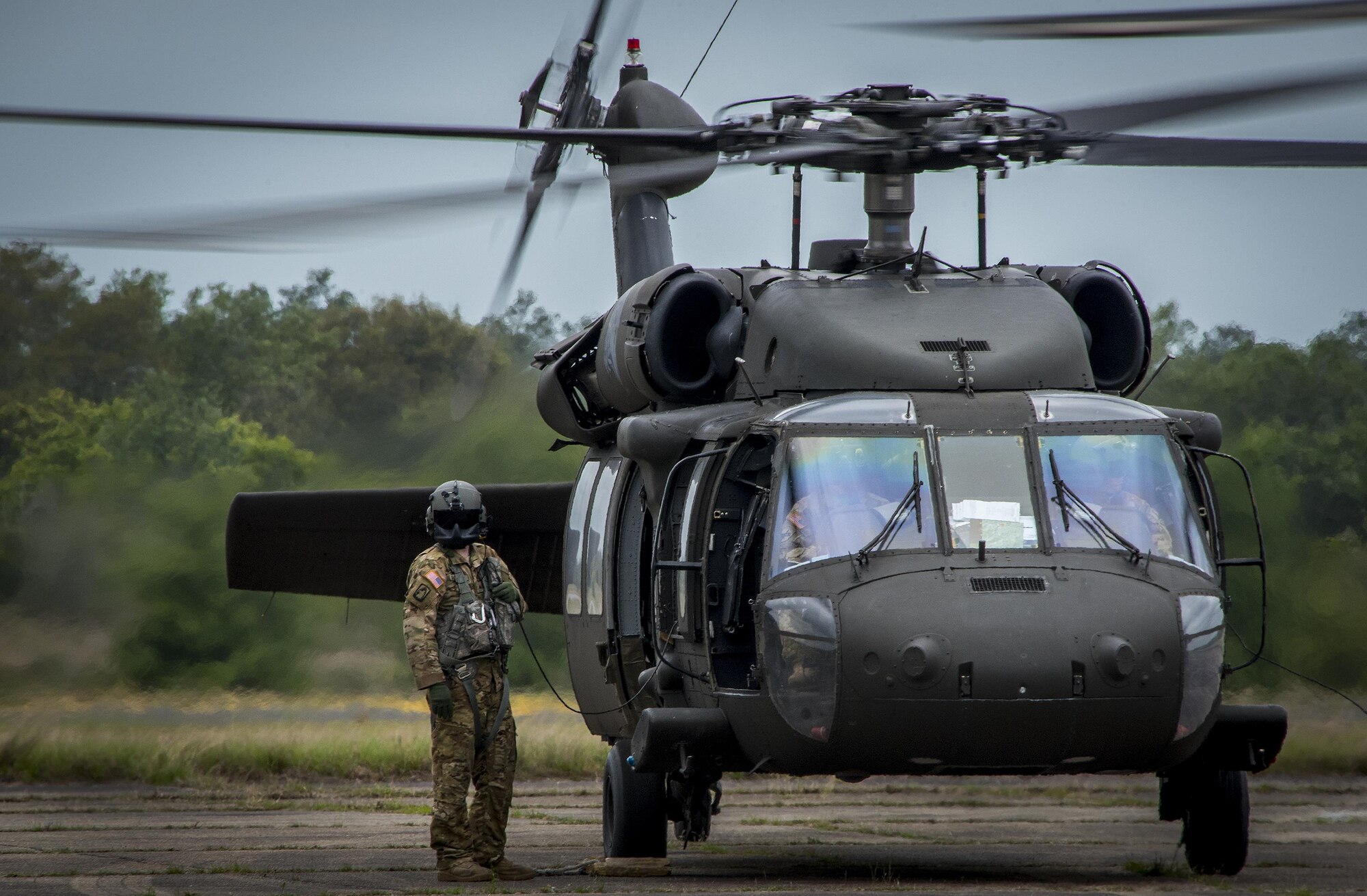 A Blackhawk helicopter aircrew member stands outside the aircraft during shutdown procedures after a flight during the 6th Ranger Training Battalion’s open house event April 29 at Eglin Air Force Base, Fla. The event was a chance for the public to learn how Rangers train and operate. The event displays showed equipment, weapons, a reptile zoo, face painting and weapon firing among others. The demonstrations showed off hand-to-hand combat, a parachute jump, snake show, and Rangers in action. (U.S. Air Force photo/Samuel King Jr.)