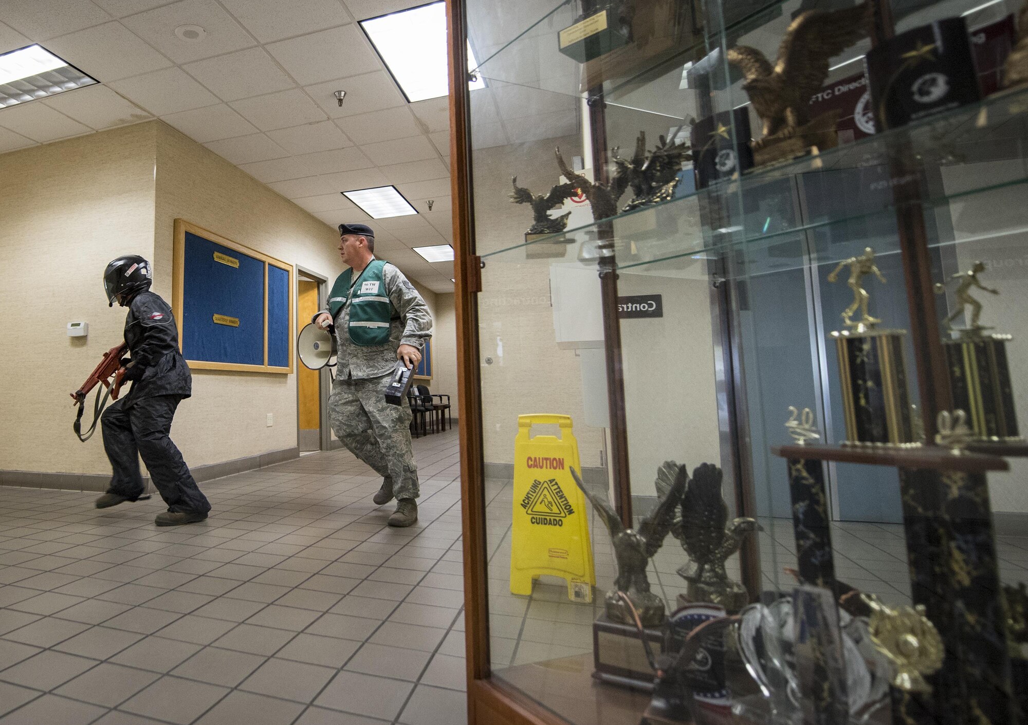 A simulated gunman searches for targets at the beginning of an active shooter exercise at Eglin Air Force Base, Fla., April 11.  The goal of the exercise was to evaluate people’s knowledge and response at the active shooter location and select lockdown locations.  (U.S. Air Force photo/Samuel King Jr.)