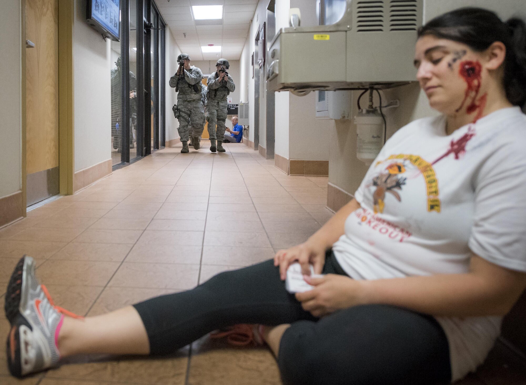Airmen from the 96th Security Forces Squadron, move toward a wounded victim during an active shooter exercise at Eglin Air Force Base, Fla., April 11.  The goal of the exercise was to evaluate people’s knowledge and response at the active shooter location and select lockdown locations.  (U.S. Air Force photo/Samuel King Jr.)