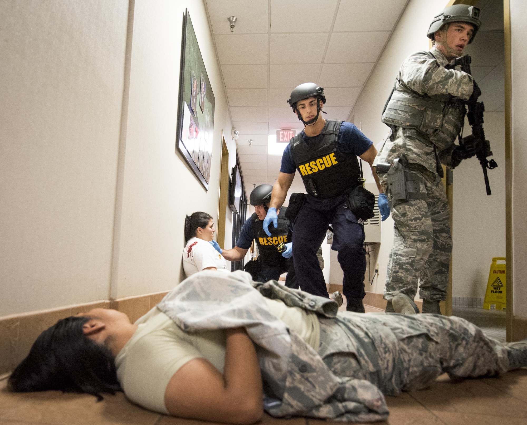 Escorted by 96th Security Forces Squadron Airmen, firefighters begin to help the simulated victims during an active shooter exercise at Eglin Air Force Base, Fla., April 11.  The goal of the exercise was to evaluate people’s knowledge and response at the active shooter location and select lockdown locations.  (U.S. Air Force photo/Samuel King Jr.)