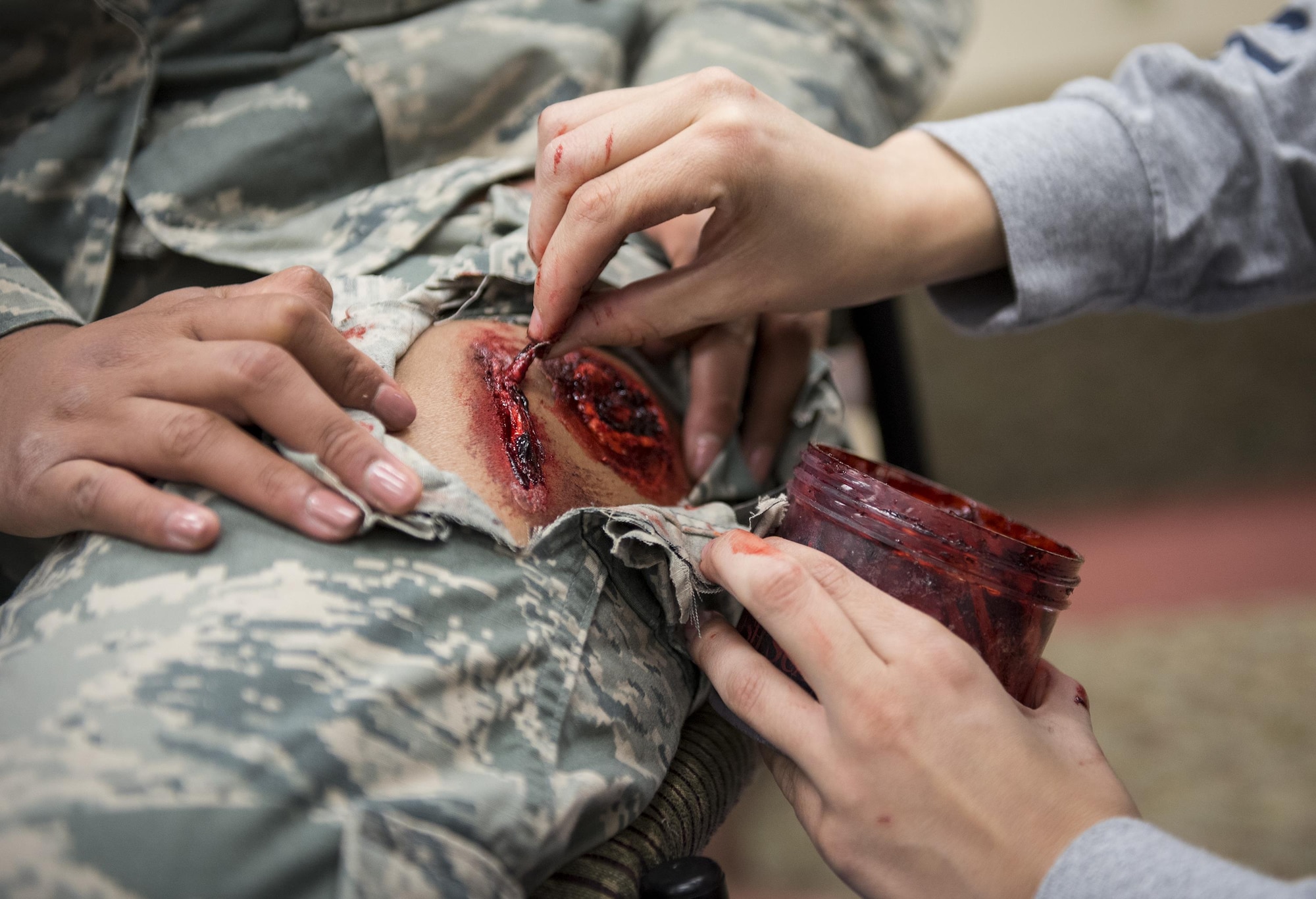 The 96th Medical Group’s moulage team member puts the finishing touches on a created bullet wound prior to the active shooter exercise at Eglin Air Force Base, Fla., April 11.  The goal of the exercise was to evaluate people’s knowledge and response at the active shooter location and select lockdown locations.  (U.S. Air Force photo/Samuel King Jr.)