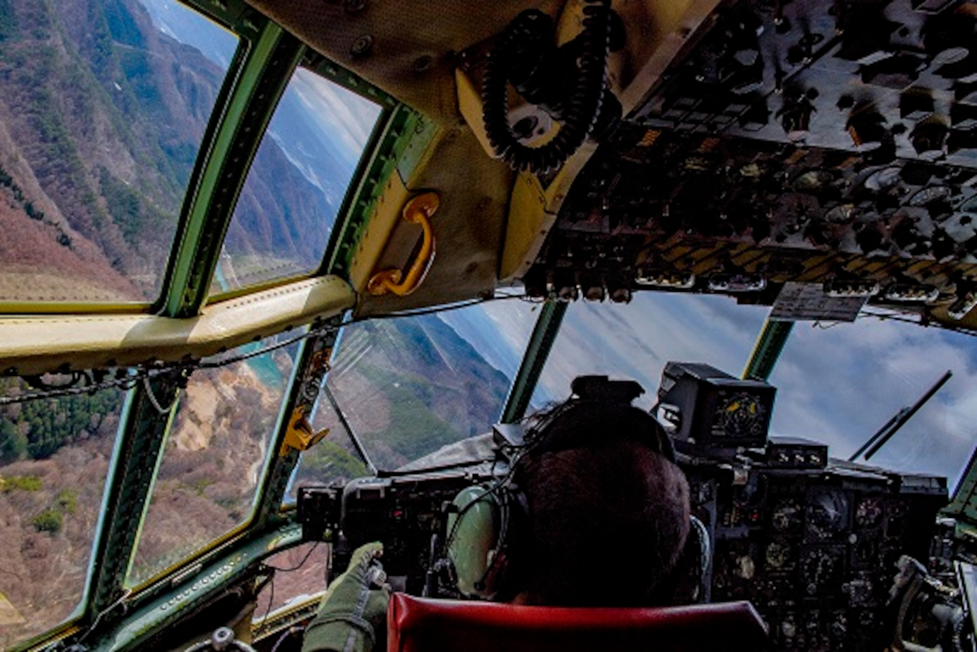 Capt. Erol S. Kelter, 36th Airlift Squadron C-130H Hercules pilot, banks the aircraft during a low altitude mountain flying and a mass container delivery system bundle drop training exercise April, 12, 2017, over mainland Japan. The training exercise was also Col. Neil R. Richardson’s, 374th Airlift Wing vice commanders, “fini” flight. (U.S. Air Force photo by Airman 1st Class Donald Hudson)