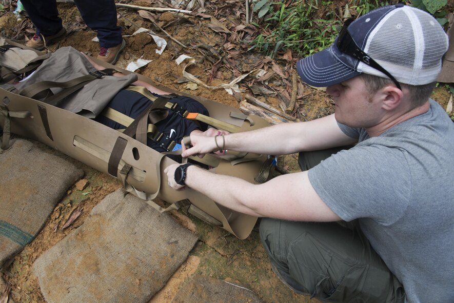 U.S. Air Force Staff Sgt. Thomas Stienke, Defense POW/MIA Accountability Agency recovery NCO, tightens a strap on a litter during medical evacuation training in Phuoc Son providence, Vietnam, May 11, 2017. The training provided each member with knowledge of how to properly set up and carry the litter in case someone needed to be evacuated. (U.S. Air Force photo by Staff Sgt. David Owsianka) 
