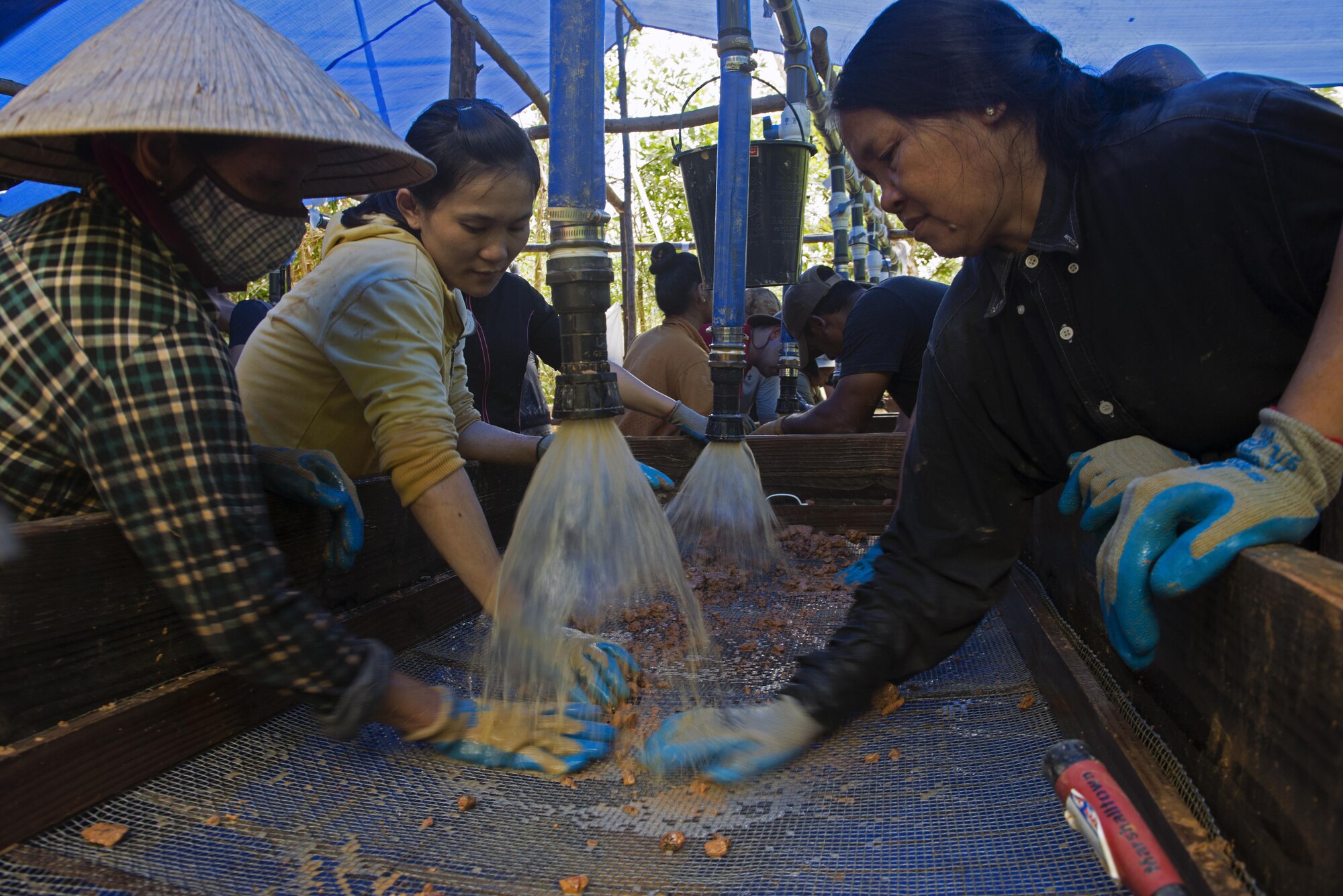 Vietnamese personnel screen soil as they work alongside Defense POW/MIA Accountability Agency members in hopes of recovering parts from a fallen aircraft or service member in Phuoc Son providence, Vietnam, May 27, 2017. The local nationals the service members increase the amount of work that is completed throughout the mission. (U.S. Air Force photo by Staff Sgt. David Owsianka) 