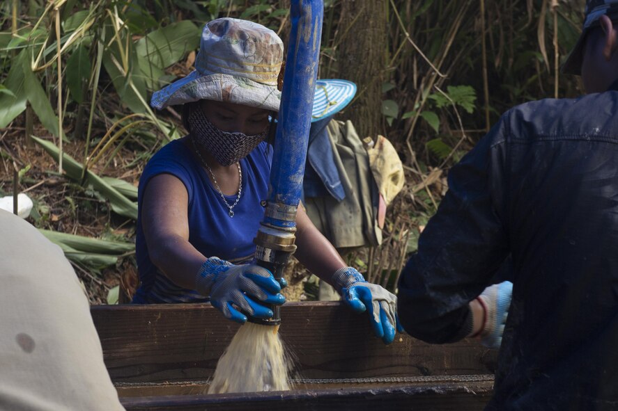 A Vietnamese worker sprays water on soil to see if there are any parts from a fallen aircraft or service member in Phuoc Son providence, Vietnam, May 27, 2017. The local nationals the service members increase the amount of work that is completed throughout the mission. (U.S. Air Force photo by Staff Sgt. David Owsianka) 