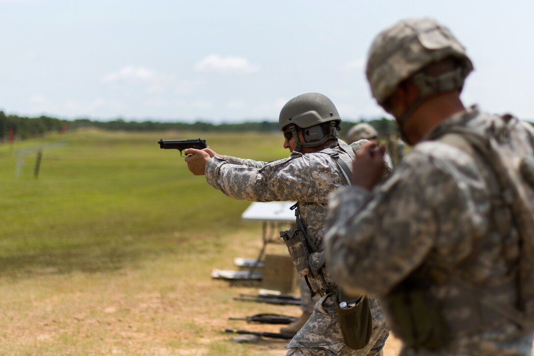A guardsman takes aim with a 9mm pistol before firing at targets during the 46th Winston P. Wilson Championships at the National Guard Marksmanship Training Center in North Little Rock, Ark., July 24, 2017. Army photo by Staff Sgt. Jeremiah Runser
