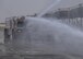 Airmen extinguish a simulated aircraft fire during Fire Immersion Training July 28, 2017, Al Dhafra Air Base, United Arab Emirates. To round out the day, Airmen rode in a firetruck while aiming the water hose to extinguish a simulated fire. (U.S. Air Force photo by Senior Airman Preston Webb)