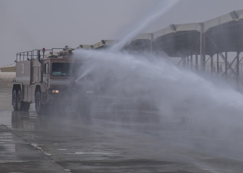 Airmen extinguish a simulated aircraft fire during Fire Immersion Training July 28, 2017, Al Dhafra Air Base, United Arab Emirates. To round out the day, Airmen rode in a firetruck while aiming the water hose to extinguish a simulated fire. (U.S. Air Force photo by Senior Airman Preston Webb)