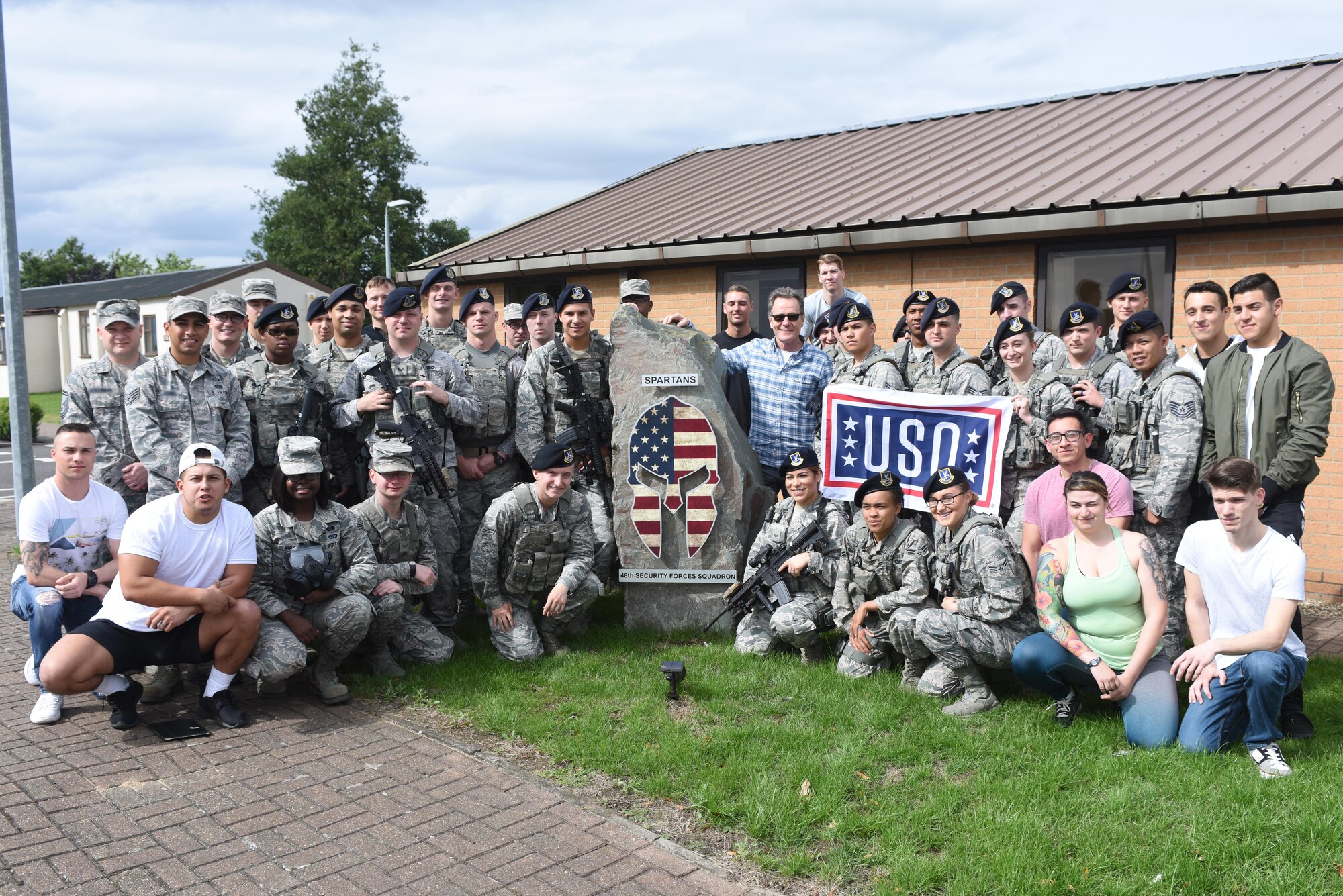 Hollywood actor Bryan Cranston poses for a photo with Airmen assigned to the 48th Security Forces Squadron at Royal Air Force Lakenheath, England, July 29. During his visit with the 48th SFS, Cranston had a chance to interact with military working dogs, take a field sobriety test and hear a capabilities brief on the weapons used by Security Forces Airmen on a daily basis. (U.S. Air Force photo/Airman 1st Class Eli Chevalier) (Portions of this image have been blurred to protect operational security)