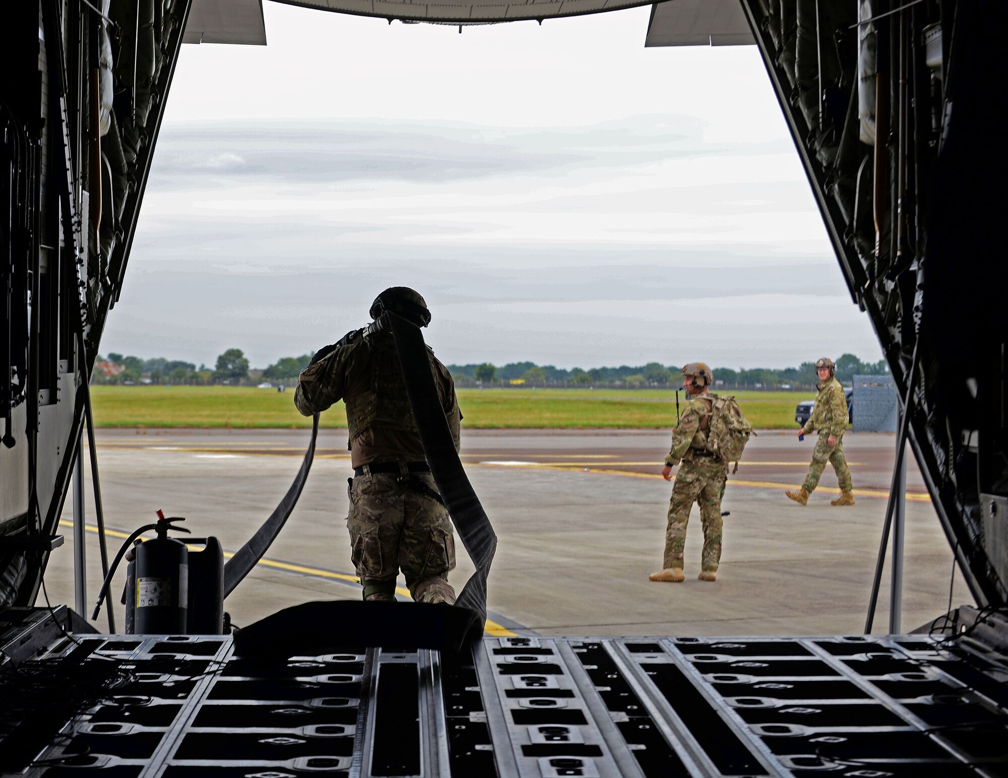 U.S. Air Force Airman 1st Class Michael Ricci, 100th Logistics Readiness Squadron forward arming and refueling point, or FARP, technician carries out one of the 100 foot hoses used to refuel four F-15C Eagles, from RAF Lakenheath, during a FARP exercise July 26, 2017, on RAF Mildenhall, England.  A FARP is an austere location near a combat zone where fuel and supplies can be transferred from one aircraft to another. (U.S. Air Force photo by Airman 1st Class Luke Milano)