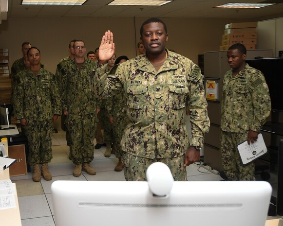 MANAMA, Bahrain (July 27, 2017) Information Systems Technician 2nd Class Lucian Matthias, assigned to U.S. Naval Forces Central Command, has the oath of enlistment administered to him by his brother Army Maj. Leon H. Matthias Jr., assigned to 532nd Military Intelligence Battalion, 501st Military Intelligence Brigade in Camp Humphreys, South Korea, not pictured on the screen, via a video teleconference. (U.S. Navy photo by Mass Communication Specialist 2nd Class Victoria Kinney)