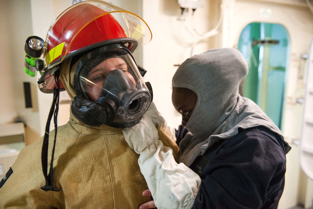 Sailors don firefighting equipment during a simulated general quarters drill aboard the amphibious assault ship USS America in the Pacific Ocean, July 24, 2017. The America is operating in the Indo-Asia Pacific region to strengthen partnerships and serve as a ready-response force for any contingency. Navy photo by Petty Officer 2nd Class Alexander A. Ventura II