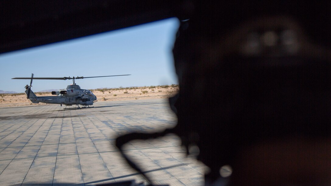 U.S. Marine Corps Staff Sgt. Ryan D. Peek, an aerial observer with Marine Light Attack Helicopter Squadron 167, Marine Air Ground Task Force 8 (MAGTF) observes an AH-1 Cobra take-off  to begin a close air support drill during Integrated Training Exercise (ITX) 5-17 at Marine Corps Air Ground Combat Center, Twentynine Palms, Calif., July 21, 2017. The purpose of ITX is to create a challenging, realistic training environment that produces combat-ready forces capable of operating as an integrated MAGTF. (U.S. Marine Corps Photo by Sgt. Kassie L. McDole)