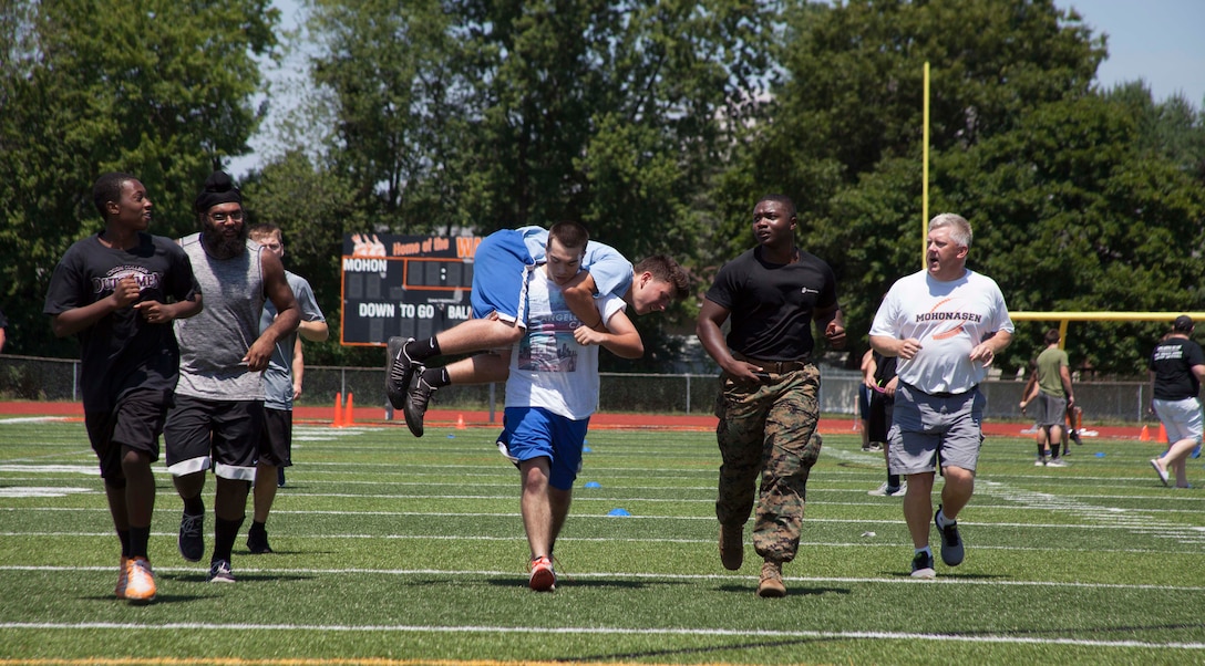 U.S. Marine Corps Sgt. Arkim Lewis, an administrative clerk with Marine Corps Recruiting Station Albany in Albany, N.Y., motivates teammates from the Mohonasen High School Football Team at Mohonasen High School in Schenectady, N.Y., July 7, 2017. Marines stationed in the local area gave the team a leadership seminar focused on team building and personal growth followed by a workout session led by the Marines. 