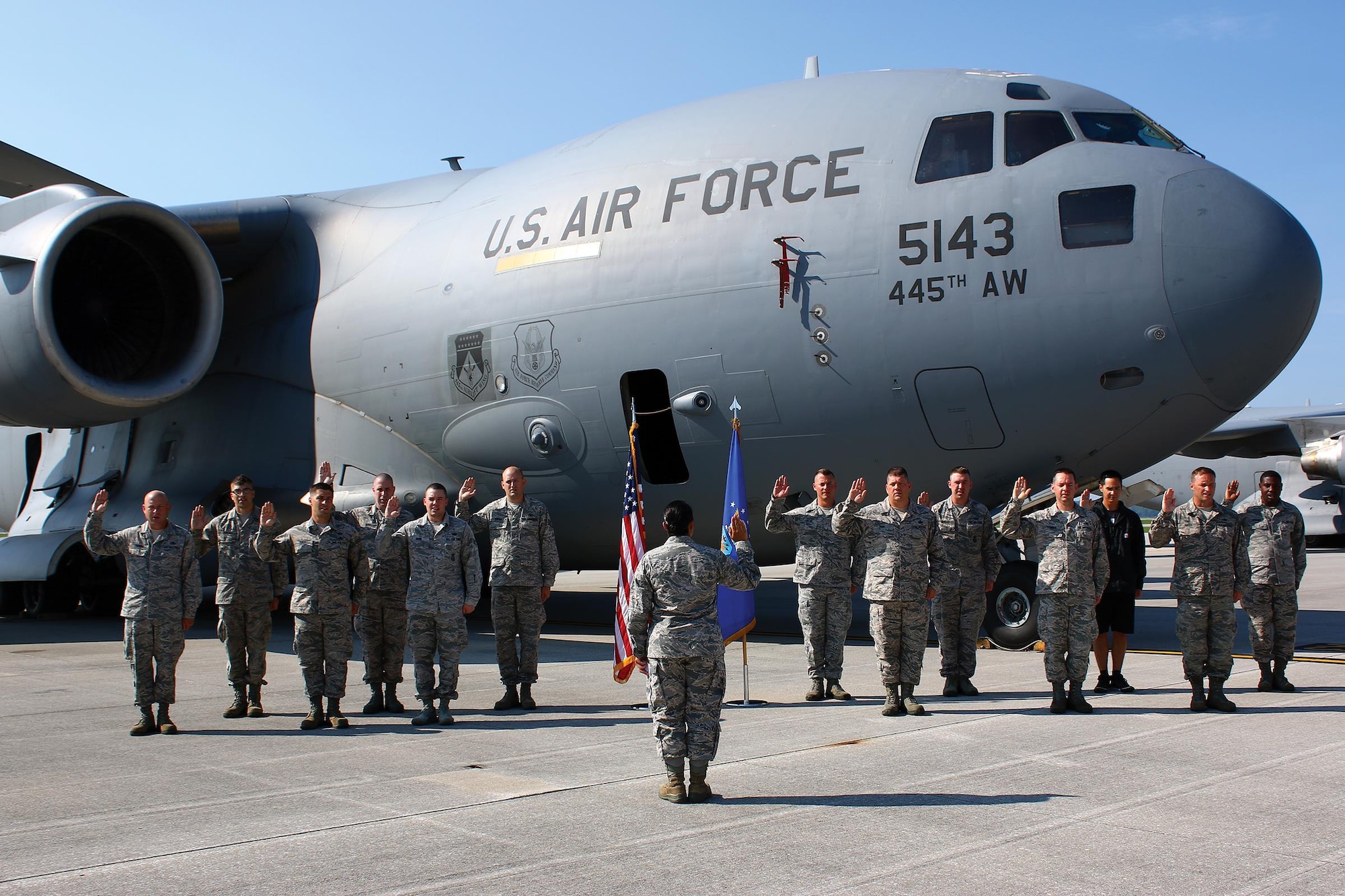 Thirteen members of the 445th Airlift Wing recite the Oath of Enlistment at a mass re-enlistment ceremony July 16, 2017 during the unit training assembly. Capt. Linda Reed, 445th Aeromedical Evacuation Squadron, administered the oath. The event was planned by wing career advisors and recruiters. (U.S. Air Force photo/Master Sgt. Patrick O’Reilly)