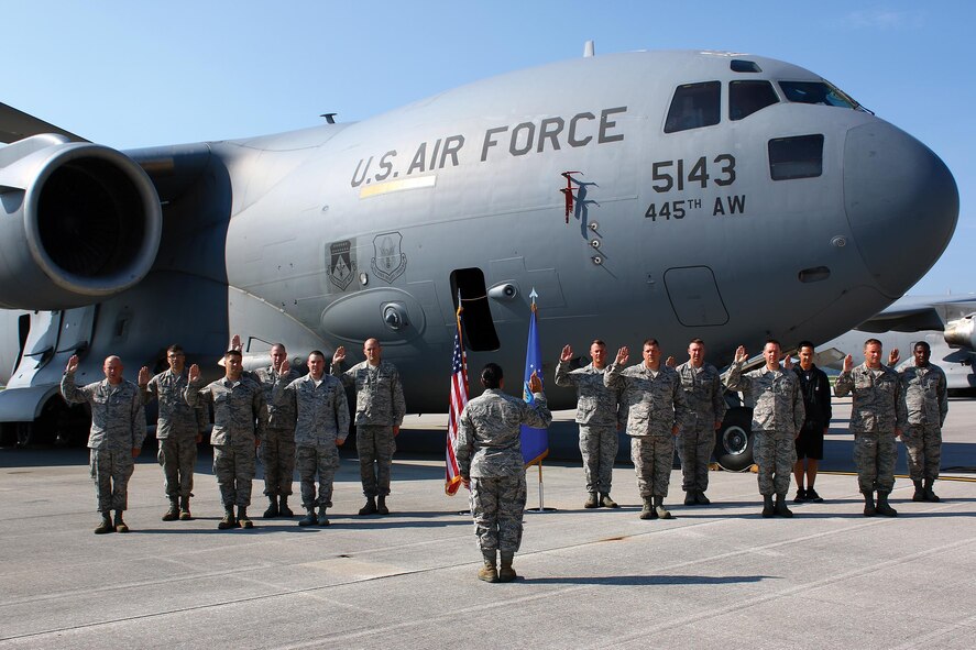 Thirteen members of the 445th Airlift Wing recite the Oath of Enlistment at a mass re-enlistment ceremony July 16, 2017 during the unit training assembly. Capt. Linda Reed, 445th Aeromedical Evacuation Squadron, administered the oath. The event was planned by wing career advisors and recruiters. (U.S. Air Force photo/Master Sgt. Patrick O’Reilly)