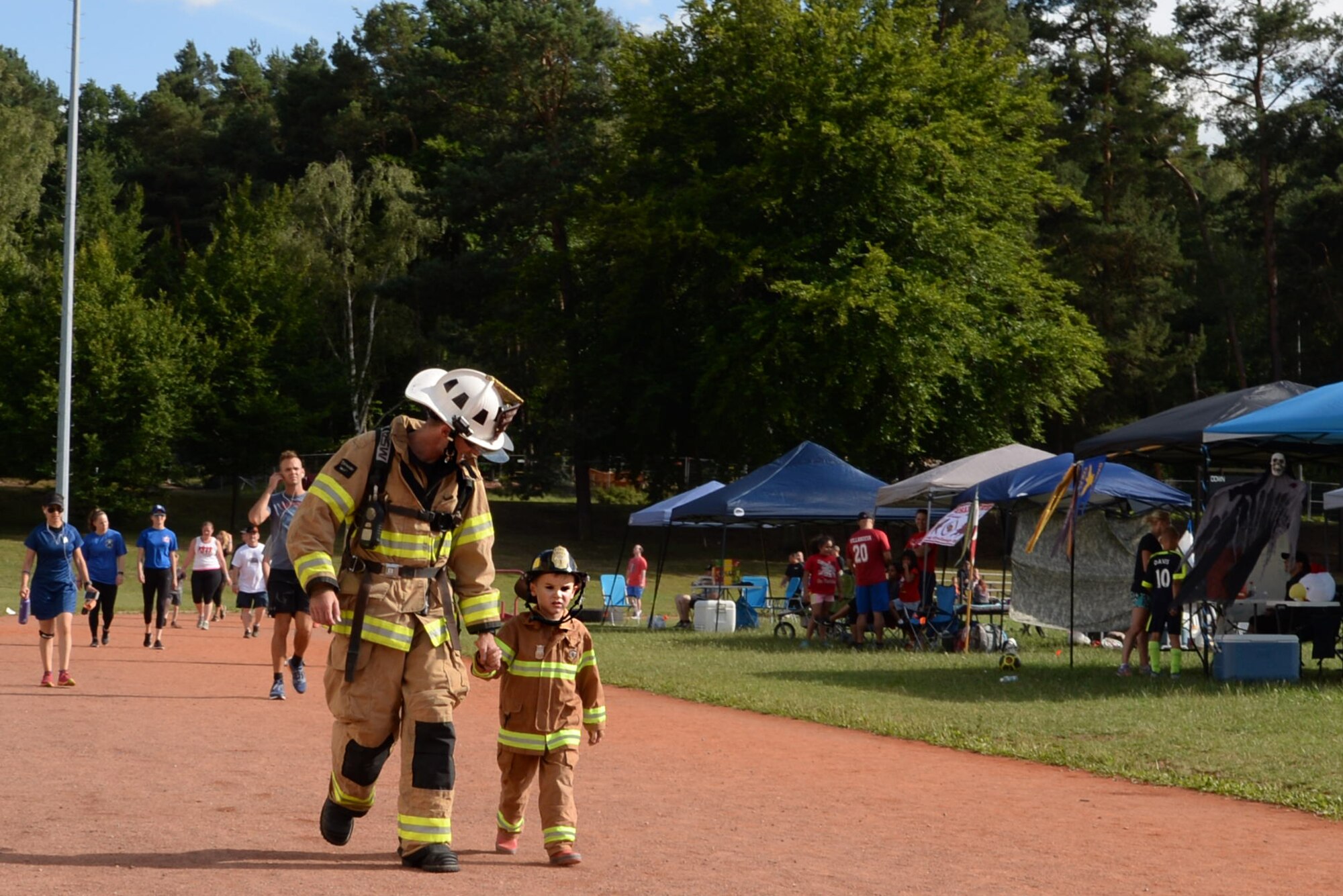 U.S. Air Force Master Sgt. Michael Ott, Air Force Installation and Mission Support Center Detachment 4 fire emergency services program manager, and his son, Aaron, run a lap during the 11th Annual Kaiserslautern Military Community Viking Challenge on Vogelweh Military Complex, Germany, July 28, 2017. Approximately 600 participants came to walk, run, and camp during the 24-hour run and walk-a-thon. (United States Air Force photo by Airman 1st Class Milton Hamilton Jr.)
