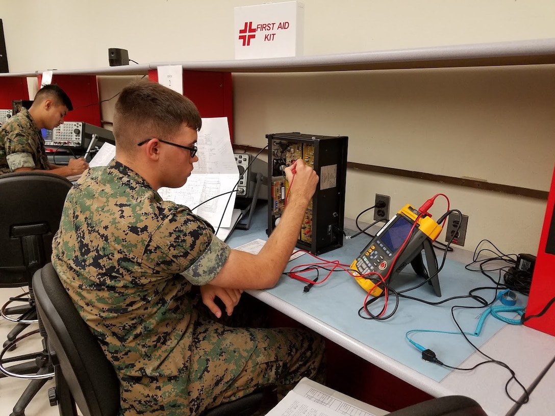 PFC Tance Brandon is seen here troubleshooting a NIDA radio trainer during the Amplitude Modulation (AM) annex of the Ground Radio Repair Course. This trainer provides an introduction to radio fundamentals and allows for hands-on troubleshooting. This training, as well as the later training Marines receive in the course, allows for understanding of how radio assets operate. This prepares the Marines for their future responsibilities as Military Occupational Specialty 2841, Ground Radio Repairers.
