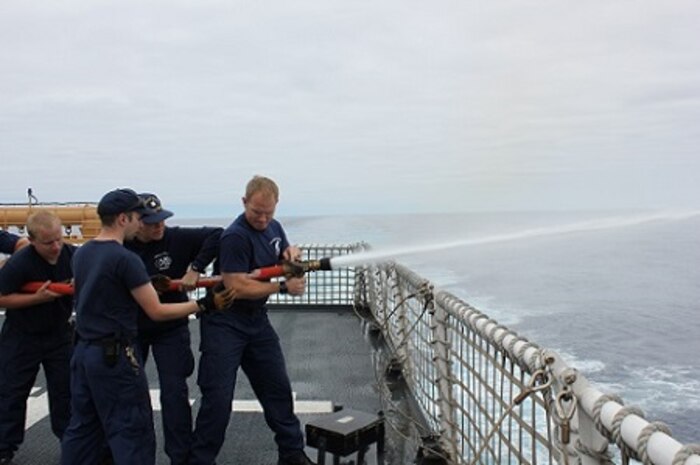 DCC David Warner instructs BM1 Kenneth Cook on hose handling techniques.