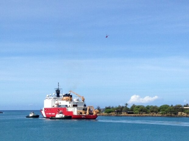 USCGC HEALY departs Honolulu, flanked by two tug boats.