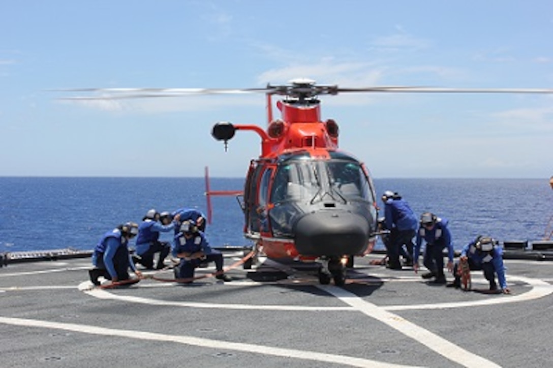 Tie down crews secure the helicopter to HEALY’s flight deck with tie-downs during flight ops.