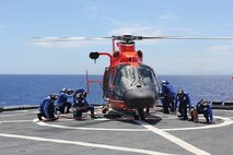 Tie down crews secure the helicopter to HEALY’s flight deck with tie-downs during flight ops.