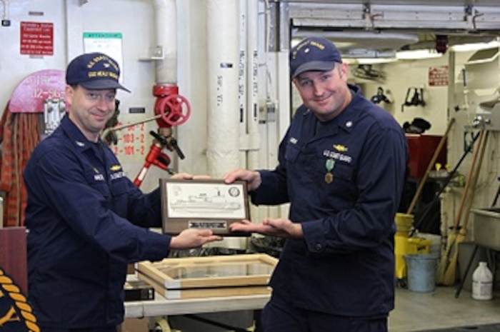 CDR Karl Lander, USCG, Ret. receives the coveted HEALY plaque, from CAPT Jason Hamilton.