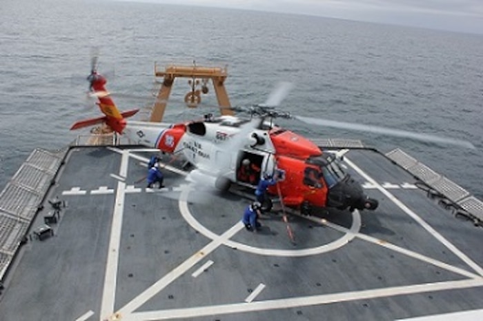 Members of the flight crew place tie-downs on the MH-60D Jayhawk during flight operations with AIRSTA Kodiak.