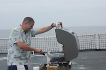 F&S2 Sterling Van Horn prepares burgers on the flight deck for the morale meal.