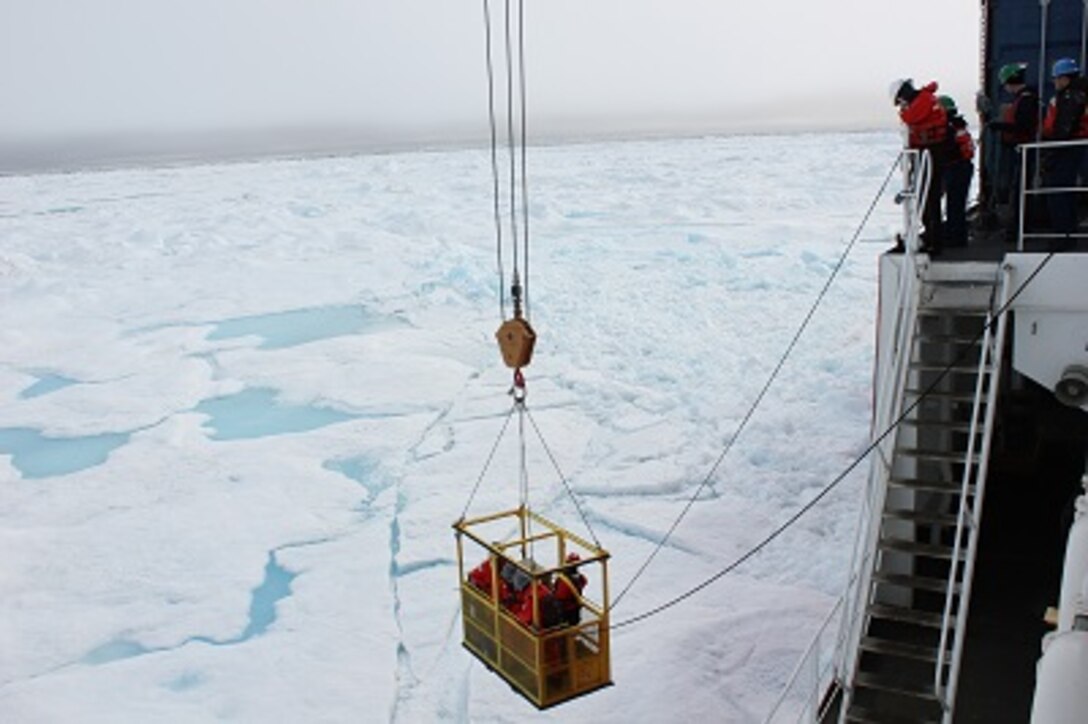 BM2 Jim Bowell deploys the man basket onto the ice to take samples. 