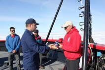 CDR William Woityra presents Jeff Welker with a flag flown aboard HEALY.