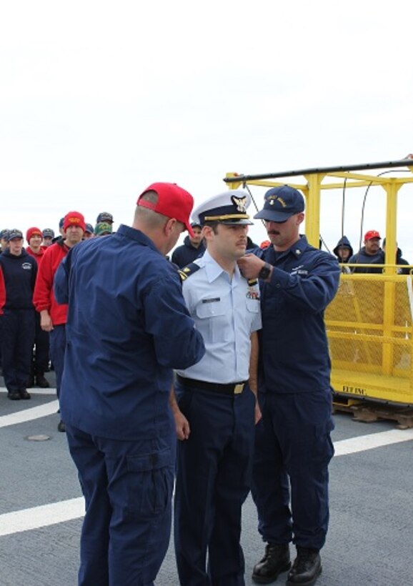 LTJG Angel Serrano is pinned by CWO4 Tim Tully and BM2 Dan Gomes.