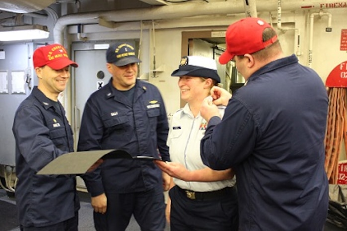 BM1 Julia Kinney is pinned by CWO4 Tim Tully and BMC John Lobherr.