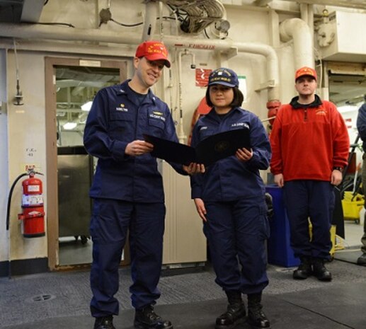 SN Sabrina Duran reads her advancement letter with CAPT Hamilton