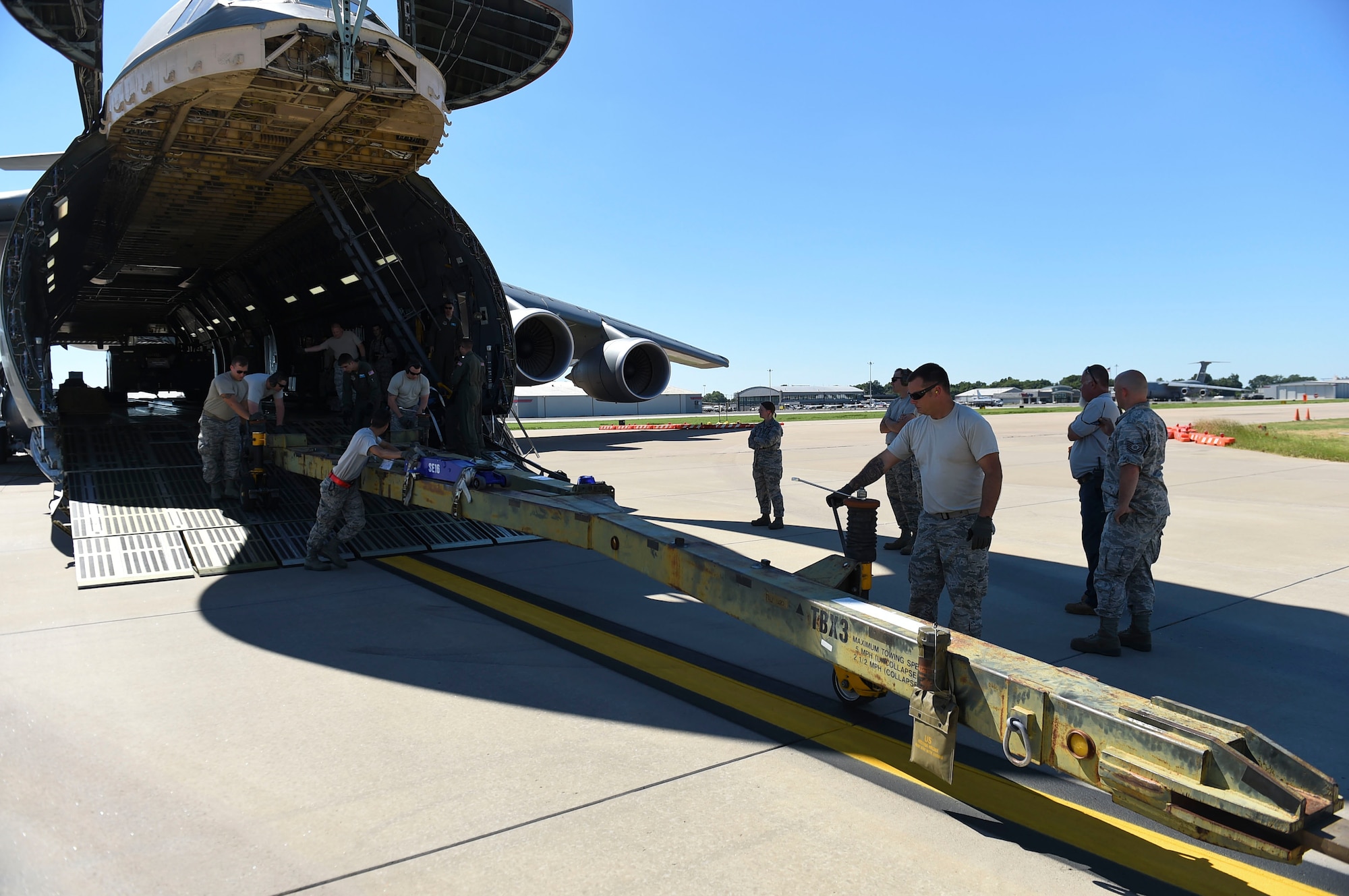 Airmen from the 19th Logistic Readiness Squadron offload towing equipment July 30, 2017 at the Clinton National Airport in Little Rock, Ark. A C-5 Galaxy, C-17 Globemaster and 10 C-130Js were loaded by Team Little Rock Airmen with more than 100 troops and thousands of pounds of cargo, consisting of supplies and aircraft parts. (U.S. Air Force photo by Staff Sgt. Harry Brexel)