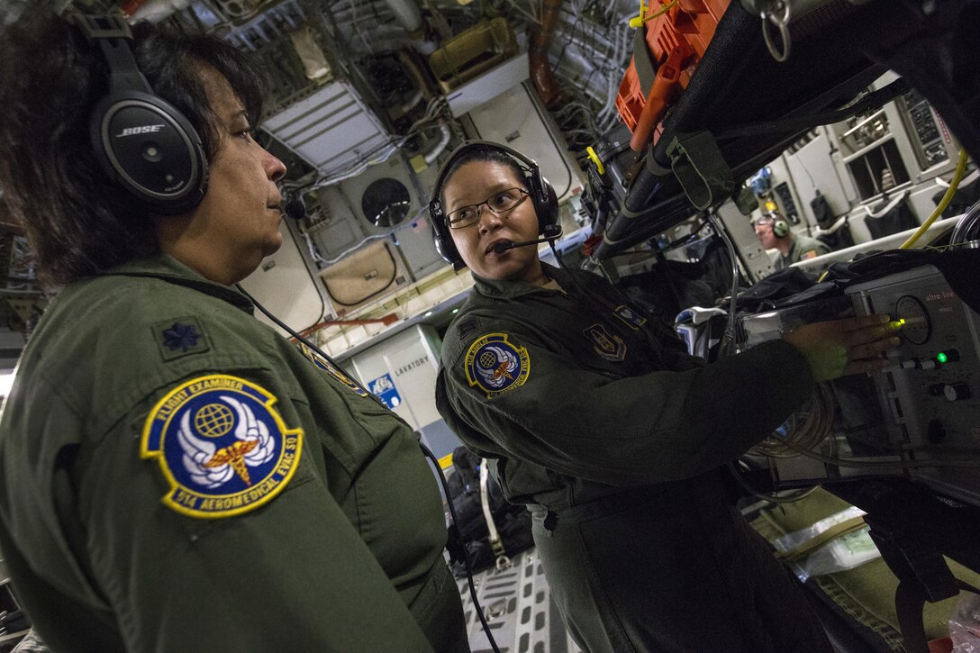 U.S. Air Force Capt. Hazel Seda, flight nurse, right, explains how a cardiac monitor is used to Lt. Col. Rosa M. Ramos, flight examiner, both with the 514th Aeromedical Evacuation Squadron, 514th Air Mobility Wing, during an aeromedical evacuation training mission onboard a 305th Air Mobility Wing C-17 Globemaster III to Nashville, Tenn., July 29, 2017. The training’s purpose is to teach flight nurses and aeromedical evacuation technicians how to respond to scenarios during the evacuation of sick or wounded personnel, and how to handle medical situations that might occur during the flight. The 514th Aeromedical Evacuation Squadron is located at Joint Base McGuire-Dix-Lakehurst, N.J. (U.S. Air Force photo by Master Sgt. Mark C. Olsen/Released)