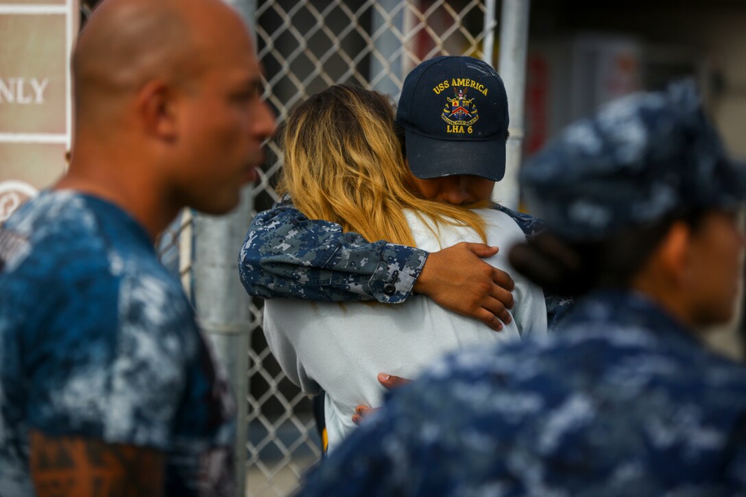 A sailor stationed aboard the USS America LHD-6 embraces his spouse before boarding the ship at Naval Base San Diego prior to departing on the America Amphibious Ready Group/15th Marine Expeditionary Unit’s Western Pacific 17-2 deployment July 7, 2017. The 15th MEU will provide a forward-deployed, flexible sea-based Marine Air-Ground Task Force capable of conducting a variety of combat and humanitarian missions. (U.S. Marine Corps photo by Sgt. Will Perkins)