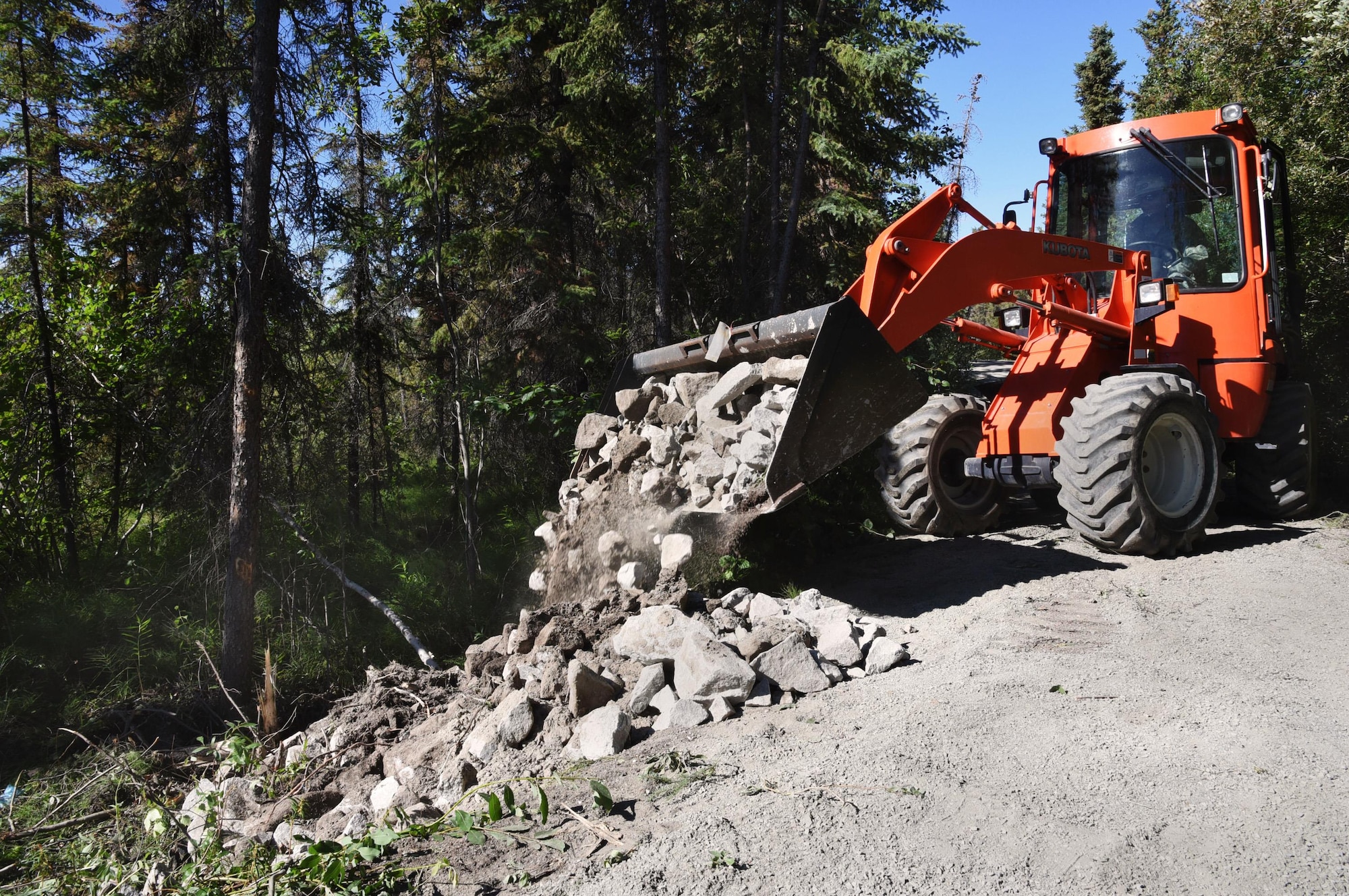 Oregon Air National Guard Senior Airman Andrew Wolf, assigned to the 142nd Fighter Wing Civil Engineers (CES) uses a front end loader to transport rock and gravel to the Nivan Lake Trail at Yellowknife, Northwest Territories, Canada, July 18, 2017. The CES members are spending two-weeks in Canada working on a variety of projects during their Deployment for Training (DFT). (U.S. Air National Guard photo/Master Sgt. John Hughel, 142nd Fighter Wing Public Affairs)