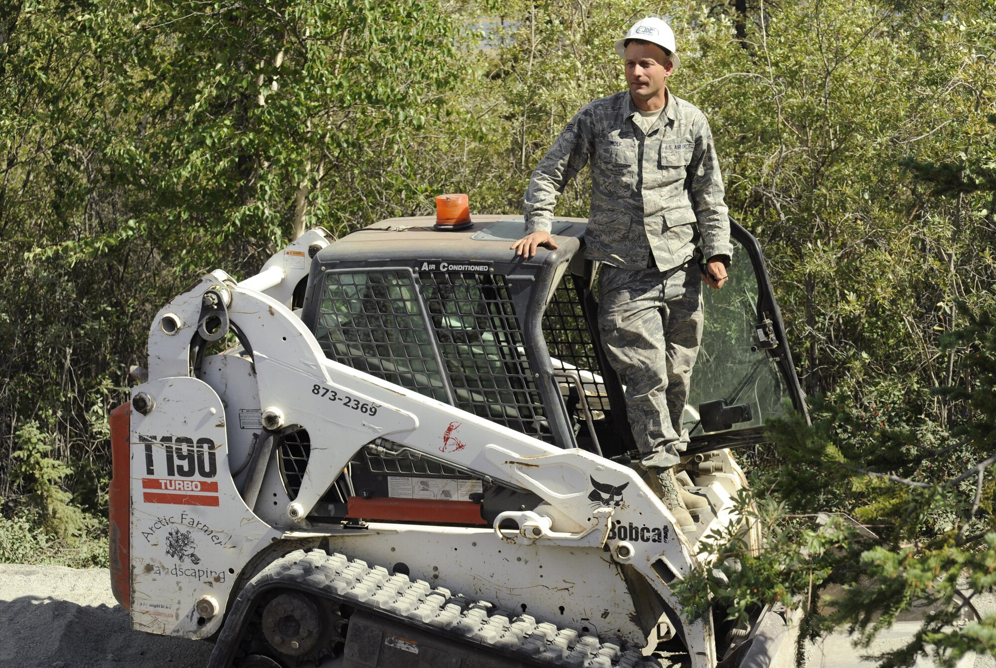Oregon Air National Guard Senior Airman Andrew Wolf, assigned to the 142nd Fighter Wing Civil Engineers (CES) takes a short break to observe the delivery of more materials for the trail extension he and other members of the CES are working on at Niven Lake Trail, Yellowknife, Northwest Territories, Canada, July 18, 2017. The CES members are spending two-weeks in Canada working on a variety of projects during their Deployment for Training (DFT). (U.S. Air National Guard photo/Master Sgt. John Hughel, 142nd Fighter Wing Public Affairs)