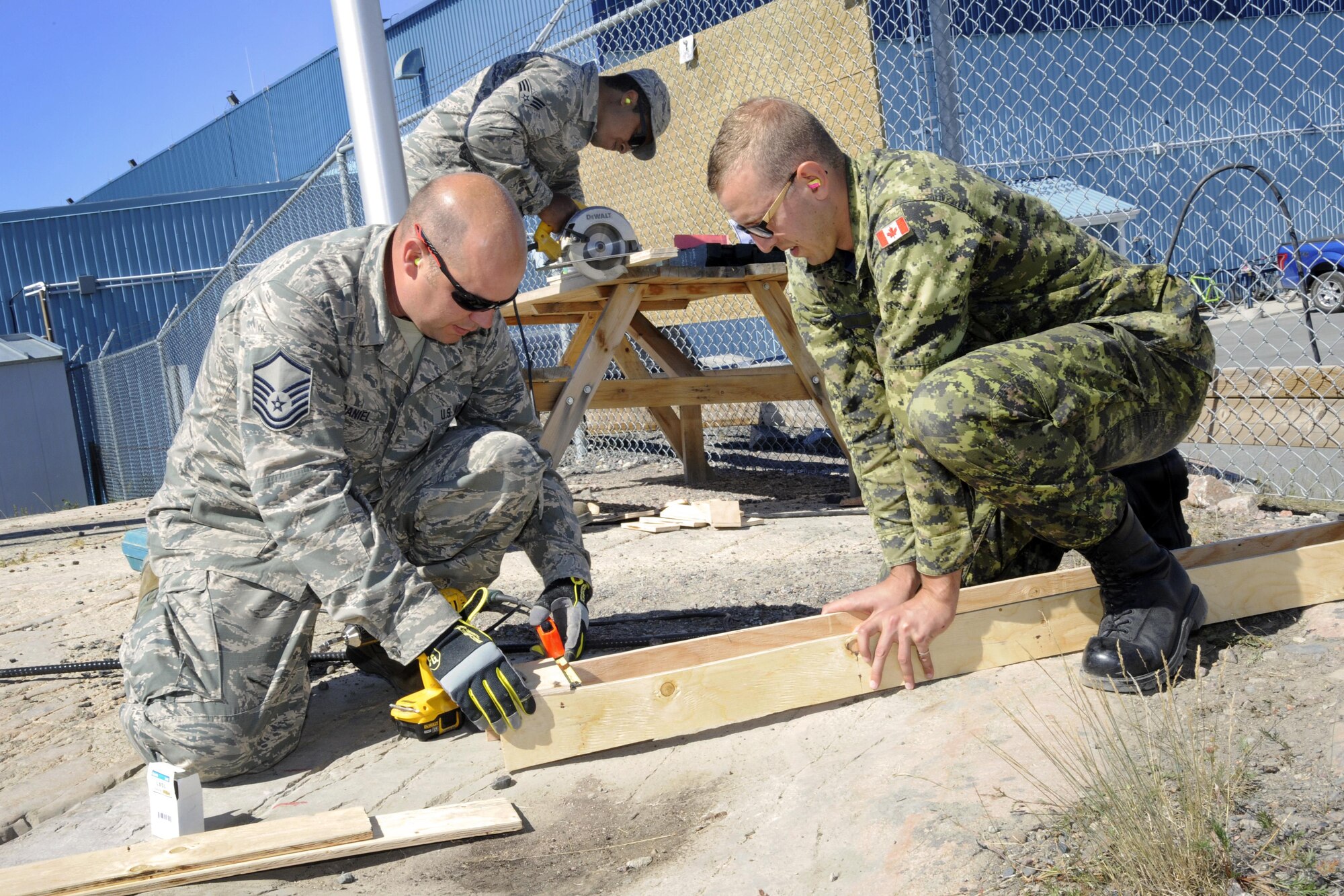 Oregon Air National Guard Master Sgt. Travis McDaniel, (left) assigned to the 142nd Fighter Wing Civil Engineer Squadron (CES) and Canadian Armed Forces Lt. Jordan Vadala (right) construct concrete form to install a new lighting project at the 440th Squadron/Escadrille, Yellowknife, Northwest Territories, Canada, July 19, 2017. (U.S. Air National Guard photo/Master Sgt. John Hughel, 142nd Fighter Wing Public Affairs)