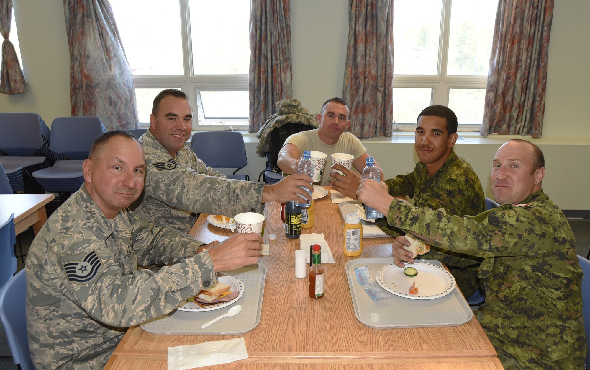 Oregon Air National Guard members along with Canadian Military members from Cold Lake, Alberta, enjoy lunch together during their joint Deployment for Training (DFT) in Yellowknife, Northwest Territories, Canada, July 20, 2017. The Civil Engineer Airmen are spending two-weeks in Canada working with Canadian Armed Forces members from Cold Lake, Alberta, Canada, on a variety of projects during their DFT. (Picured from left to right) Tech. Sgt. David Sherman, Staff Sgt. Tyler O'Bryant, Staff Sgt. Michael Templeton, Private Corey Blackmore and Corporal Kyle Burrow. (U.S. Air National Guard photo/Master Sgt. John Hughel, 142nd Fighter Wing Public Affairs)
